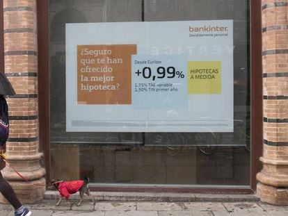 Una persona pasa por delante de un anuncio hipotecario en Sevilla.