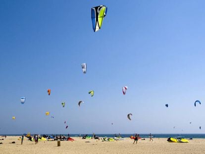 Un grupo de bañistas hacen volar sus cometas en la playa de Tarifa, Cádiz.