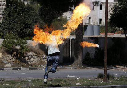Un palestino se prende fuego al lanzar un cóctel molotov durante una protesta en Hebrón (Palestina). Los ataques y disturbios de los últimos 13 días se han cobrado la vida de siete israelíes y 29 palestinos.