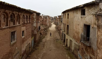 Una guia turística travessa un carrer desert al poble abandonat de Belchite, a Aragó.