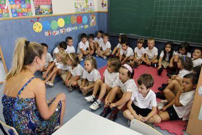 Un grupo de alumnos sigue las explicaciones de una profesora en un colegio en la comunidad de Madrid