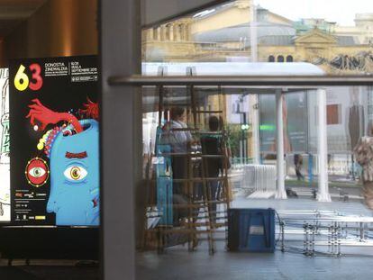 Preparativos de la 63ª edición del Festival de San Sebastián, ante una de sus sedes, el Teatro Victoria Eugenia (detrás). En primer término, el cartel de este año.