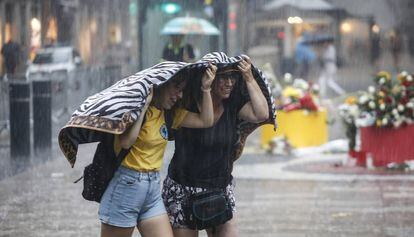 Dues dones intenten protegir-se a Barcelona de la tempesta del 17 d'agost.