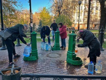 Ciudadanos llenan botellas y garrafas de agua en una fuente pública de Kiev este lunes.