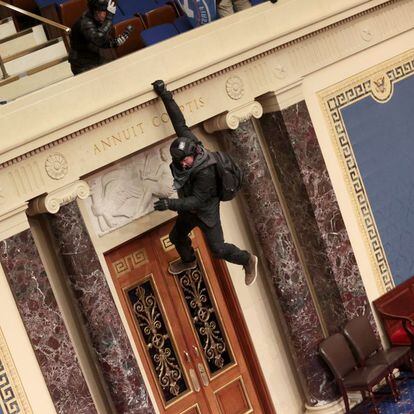 Un manifestante colgando del balcón en el interior de la Cámara del Senado.  