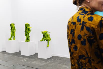 Una mujer junto a las obras 'Farmer Girl', 'Farmer Boy', y 'Planter', de Kim Simonsson, este miércoles durante la inauguración de Arco Madrid 2024.