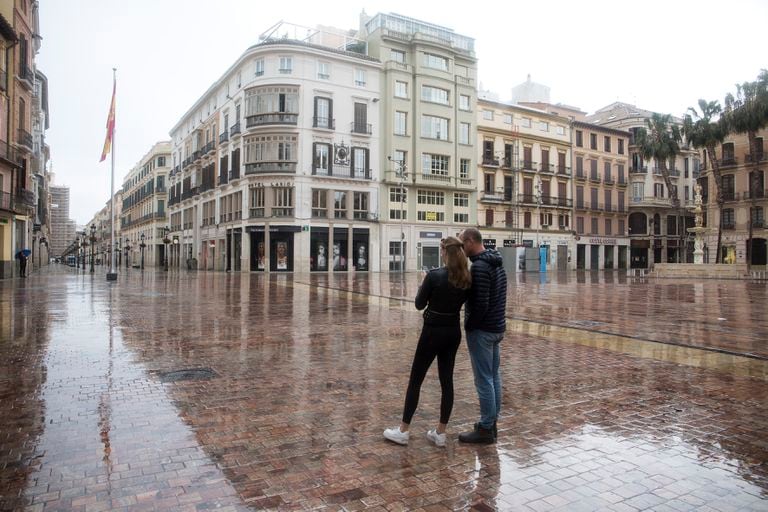Dos turistas en una desierta calle Larios, en Málaga.