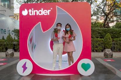 Una pareja en un puesto publicitario de Tinder en Bangkok, Tailandia, el 14 de febrero de 2022.   