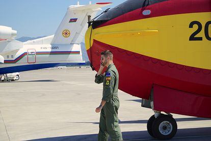 El capitán piloto Reinaldo Fernández Boyero, del 43 Grupo de la Fuerza Aérea, recibe instrucciones al teléfono en el aeropuerto de Dalaman (Turquía). Detrás un avión antiincendios de Azerbaiyán que también participa en las labores de extinción.