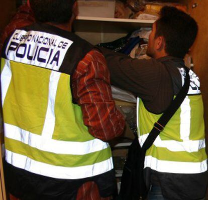 Varios agentes, durante el registro de la casa del detenido.