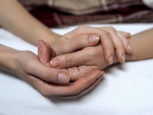 Una mujer le coge la mano a otra, en una foto de archivo.