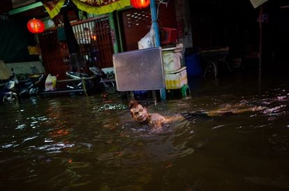 Un hombre nada en una calle del barrio de China Town, en Bangkok