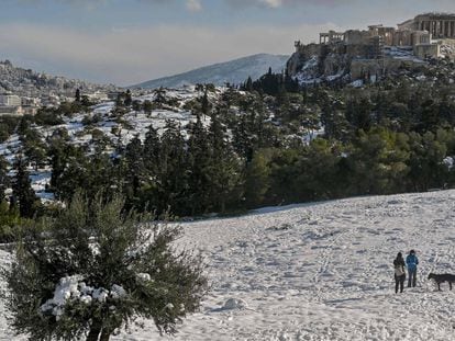 Gente que camina en la colina Pnyx cubierta de nieve en Atenas después de una tormenta de nieve el 25 de enero de 2022. Grecia amplió el feriado general hasta el 26 de enero, para evitar movimientos de personas ya que Grecia vive un frente frío con fuertes nevadas y temperaturas muy bajas.