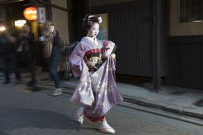 Turistas fotografiando a una geisha en el barrio de Gion, en Kioto (Japón).
