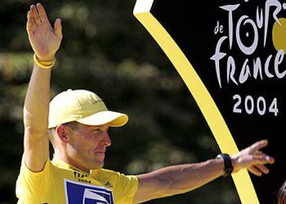 Lance Armstrong saluda  desde el podio de los Campos Elíseos.