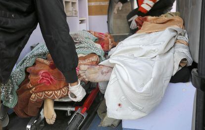 Los cuerpos de dos palestinos son transportados al hospital de Al Aqsa, tras los ataques israelíes de este viernes en Deir el Balah, en el centro de la Franja. 