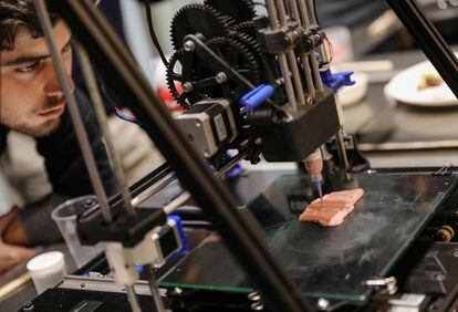 Una impresora 3D elabora un filete vegano, bajo la atenta mirada de un estudiante de la Escuela de Cocina de Barcelona, el 25 de febrero de 2020.