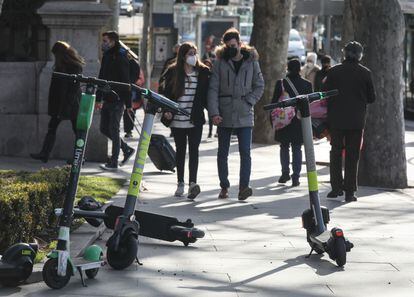 Varios patinetes obstaculizan el paso de los peatones en una acera del centro de Madrid. 