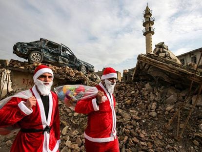 Dos jóvenes Papá Noel reparten regalos por Mosul.