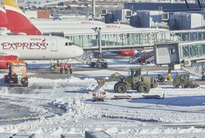 Varias excavadoras de la Unidad Militar de Emergencias (UME) trabajan para quitar la nieve y el hielo de la pista del aeropuerto Madrid-Barajas Adolfo Suárez, en Madrid (España).