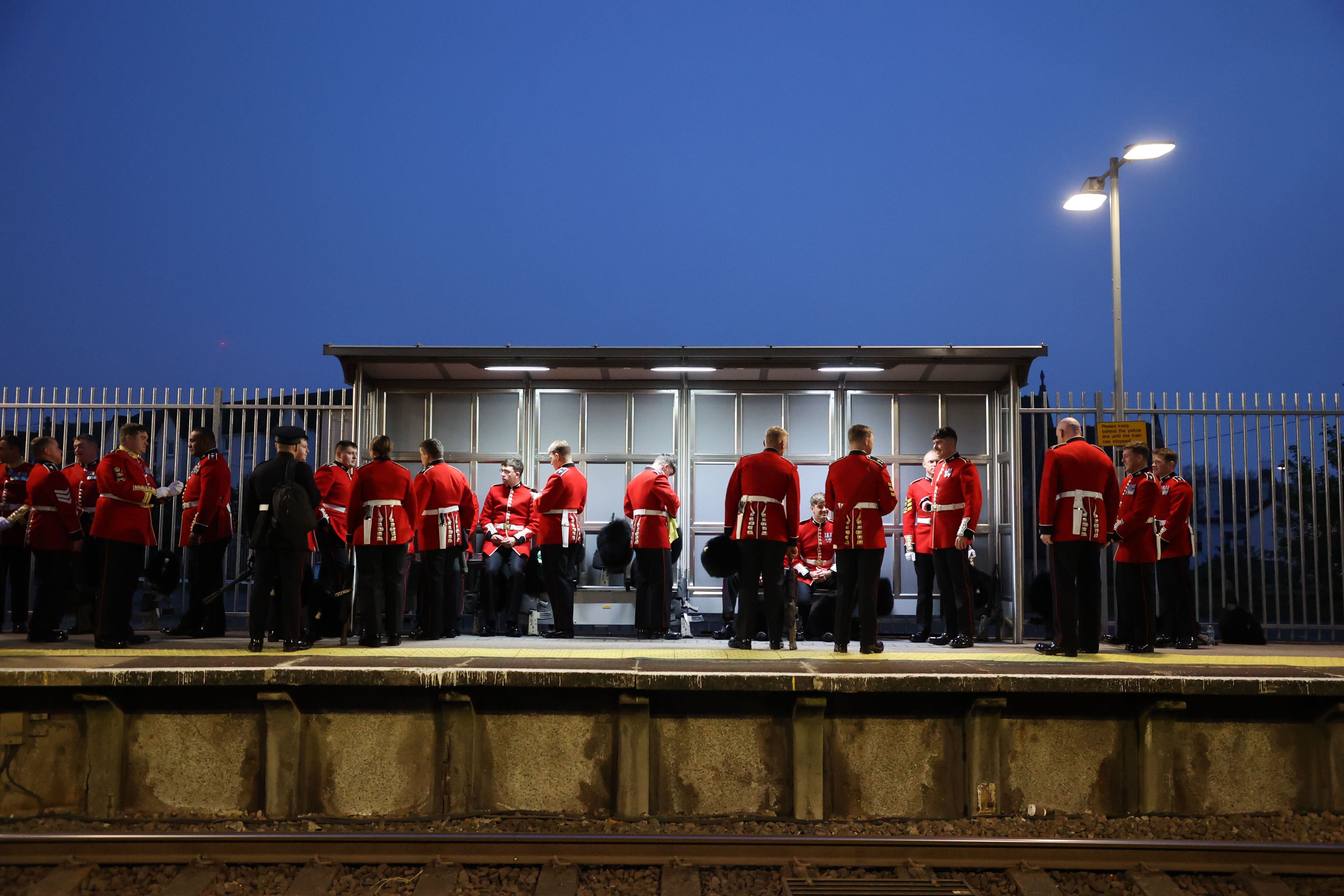 Soldados, vestidos de uniforme de gala, esperan al tren en la estación de Waterloo para dirigirse a la ceremonia de coronación de Carlos III. 