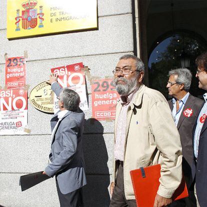 Toxo, pegando un cartel de la huelga, y Méndez, en primer término, en el Ministerio de Trabajo.