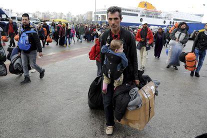 Un migrante llega este martes con un bebé a Atenas desde las islas.