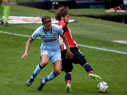 Iker Muniain, mediapunta del Athletic, protege el balón ante Marcos Llorente este domingo en San Mamés.