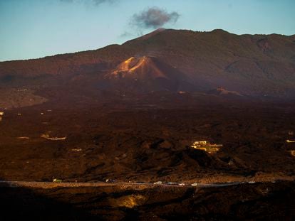 Carretera que cruza la colada de lava en la isla de La Palma. Al fondo, el volcán de Cumbre Vieja.