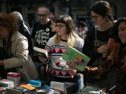 23/04/19 Una chica mira libros junto a una rosa en una de las paradas de libros de la Rambla.
 Diada de Sant Jordi, dia del Libro y la Rosa. Barcelona, 23 de abril de 2019 [ALBERT GARCIA] 
 