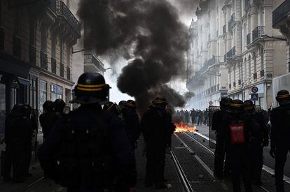 Varios manifestantes queman contenedores en Burdeos durante las protestas contra la reforma de las pensiones del presidente Macron, este jueves.