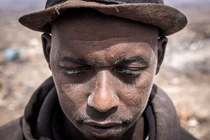 Mamadou, un reciclador de Guinea, posa para un retrato con el rostro cubierto de polvo en el basurero de Mbeubeuss, en Dakar, el 14 de julio de 2021.