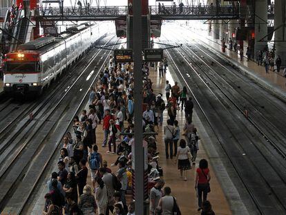 Viajeros esperando el tren en los andenes  en la estación de Atocha