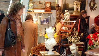 Una mujer mira los objetos de uno de los puestos de la Fira de Brocanters.