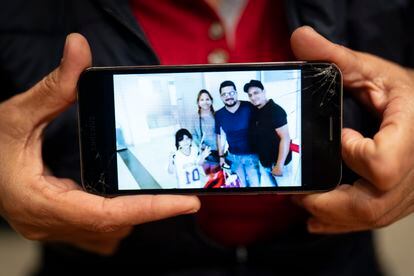 Livia Pieruzzini sostiene su celular con la foto de sus familiares desaparecidos.