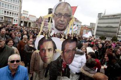 Miles de personas se manifiestan por las calles de Ferrol en demanda de contratos que permitan reanudar la actividad industrial en el sector naval. En la imagen los retratos del ministro de Hacienda, Cristóbal Montoro; el alcalde de Ferrol, José Manuel Rey (i), y el presidente de la Xunta de Galicia, Alberto Núñez Feijóo, colgados de una caña de pescar en la plaza de Armas, lugar en el que finalizó la marcha.