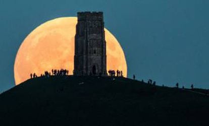 Imagen de una gran luna llena en Glastonbury Tor, Inglaterra.