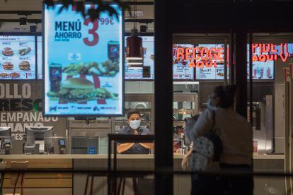 Una clienta se dispone a entrar en un restaurante de Madrid minutos antes del comienzo del estado de alarma.
