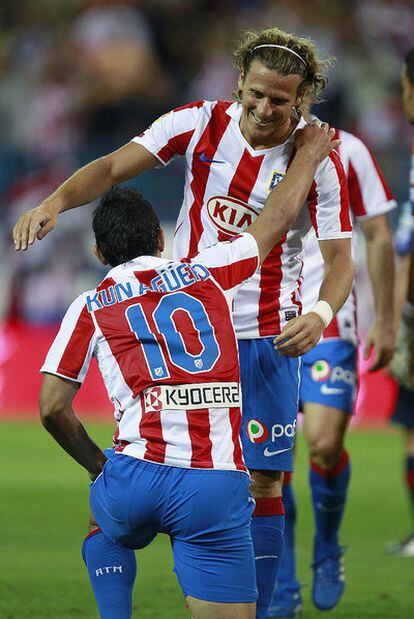 Forlán celebra su gol contra el Sporting con Agüero.