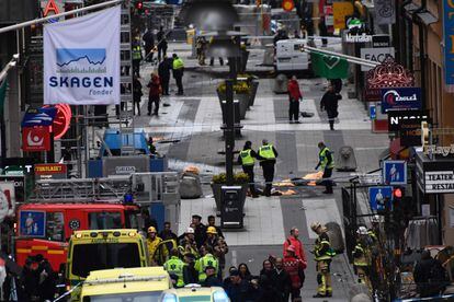 Los servicios de emergencias trabajan en la escena del atentado, donde un camión se empotró contra los escaparates de Ahlens en la calle Drottninggatan en Estocolmo (Suecia).