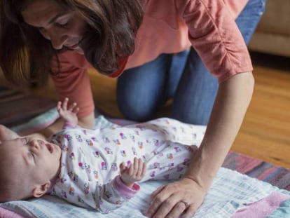 Una mujer con su bebé. Las mujeres trabajan dos horas más al día que los hombres en el hogar, según el informe 'Coste de oportunidad de la brecha de género en la conciliación'. / GETTY | ATLAS