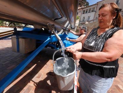 Dos mujeres recogen agua de una cuba en el centro de Vacarisses. © Foto: Cristóbal Castro.