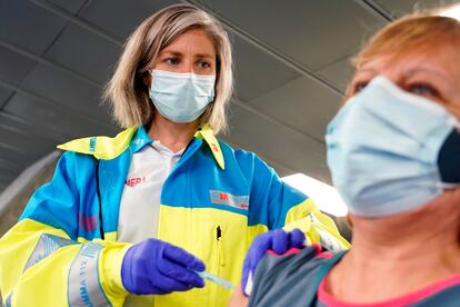 Una enfermera del servicio SUMMA 112, vacuna a una mujer con la vacuna de AstraZeneca en el polideportivo WiZink, este miércoles.