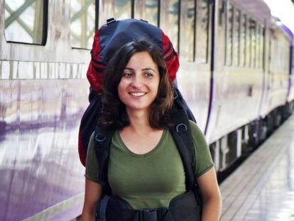 Una joven mochilera camina en una estación de tren.