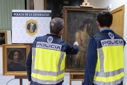 Dos agentes observan las pinturas atribuidas a Diego Velázquez y a Tiziano, pero que eran falsificaciones que habían salido al mercado.