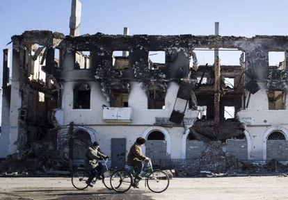 Dos personas pasean en bicicleta frente a los restos de un edificio de Debáltsevo (Donetsk, Ucrania), el 24 de febrero.