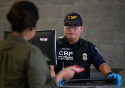 Un agente de migración entrevista a una visitante en California.