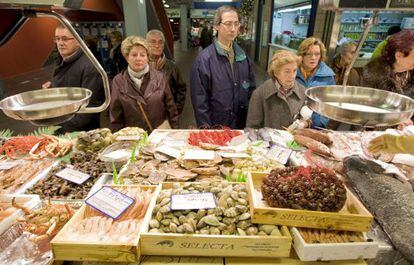 Un grupo de personas hacen cola ante una pescader&iacute;a.