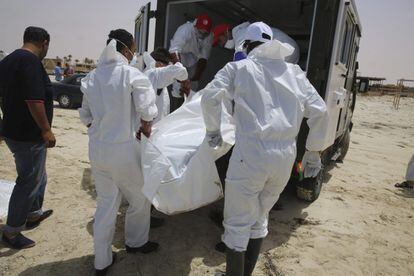 Varias personas recogen los cuerpos sin vida de inmigrantes que han aparecido en una playa en Zuwarah al oeste de Trípoli en Libia.