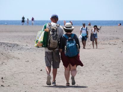 Dos turistas camina por la playa de La Tejita, en el sur de Tenerife, este viernes.